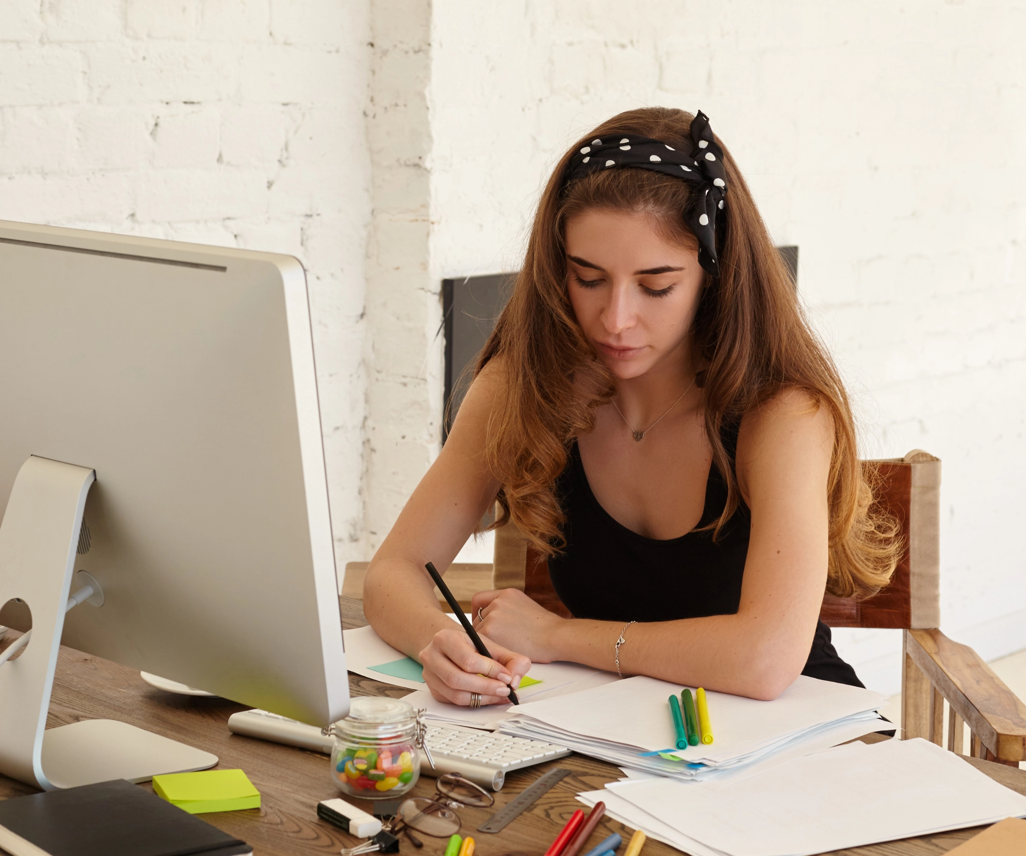Aluna estudando em casa com computador e caderno