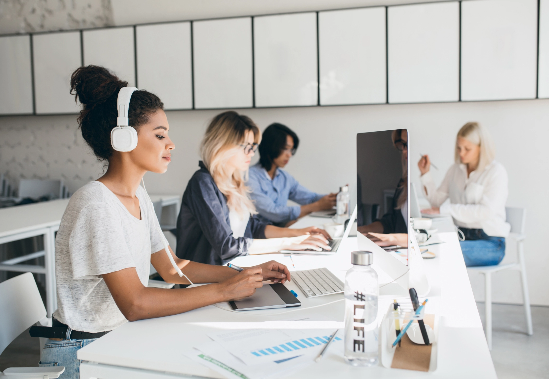 Pessoas estudando em grupo com notebooks e materiais